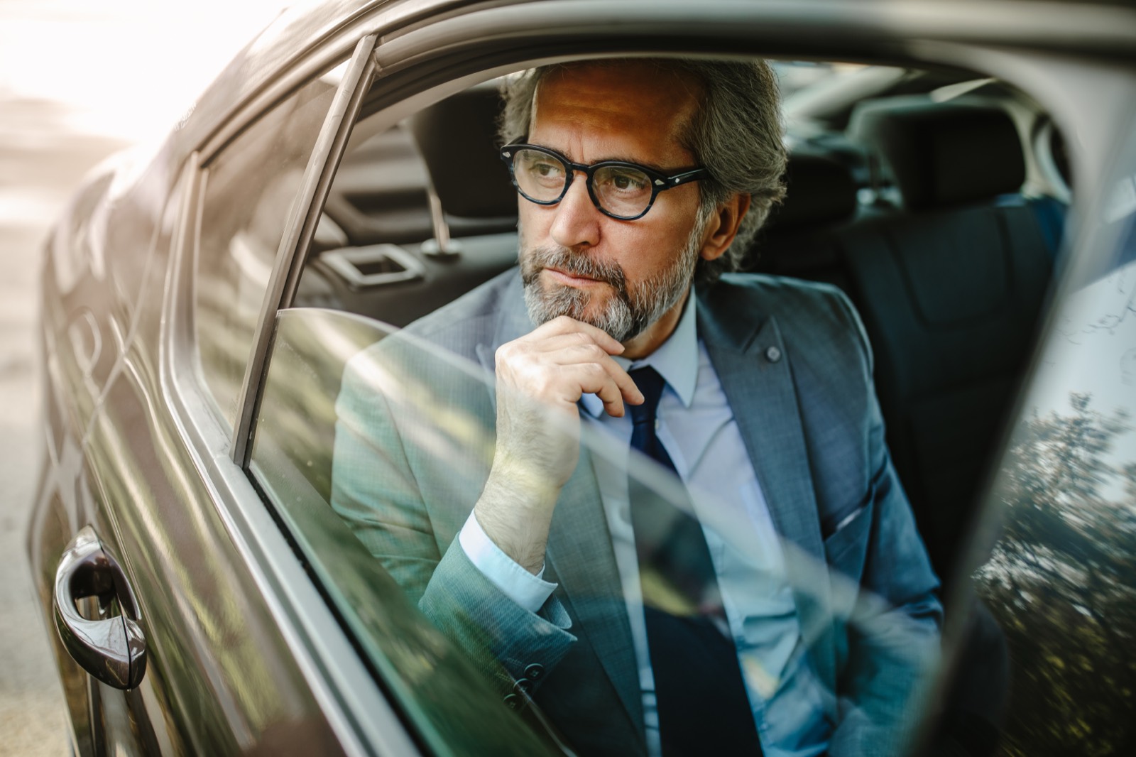Ejecutivo de negocios viajando en el asiento trasero